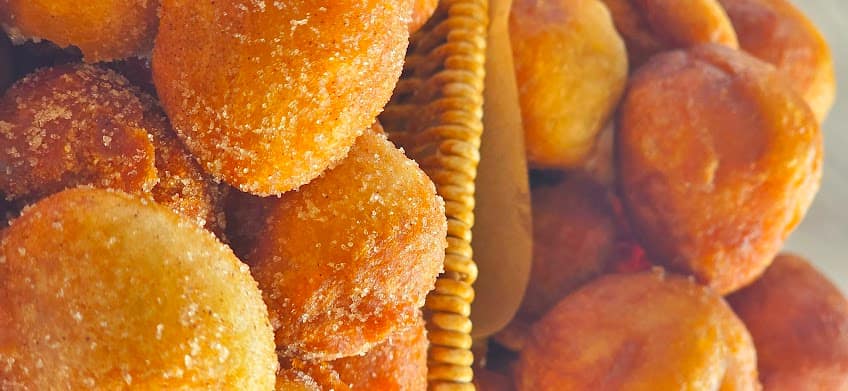 Golden, sugar-dusted puff-puff piled in a serving basket